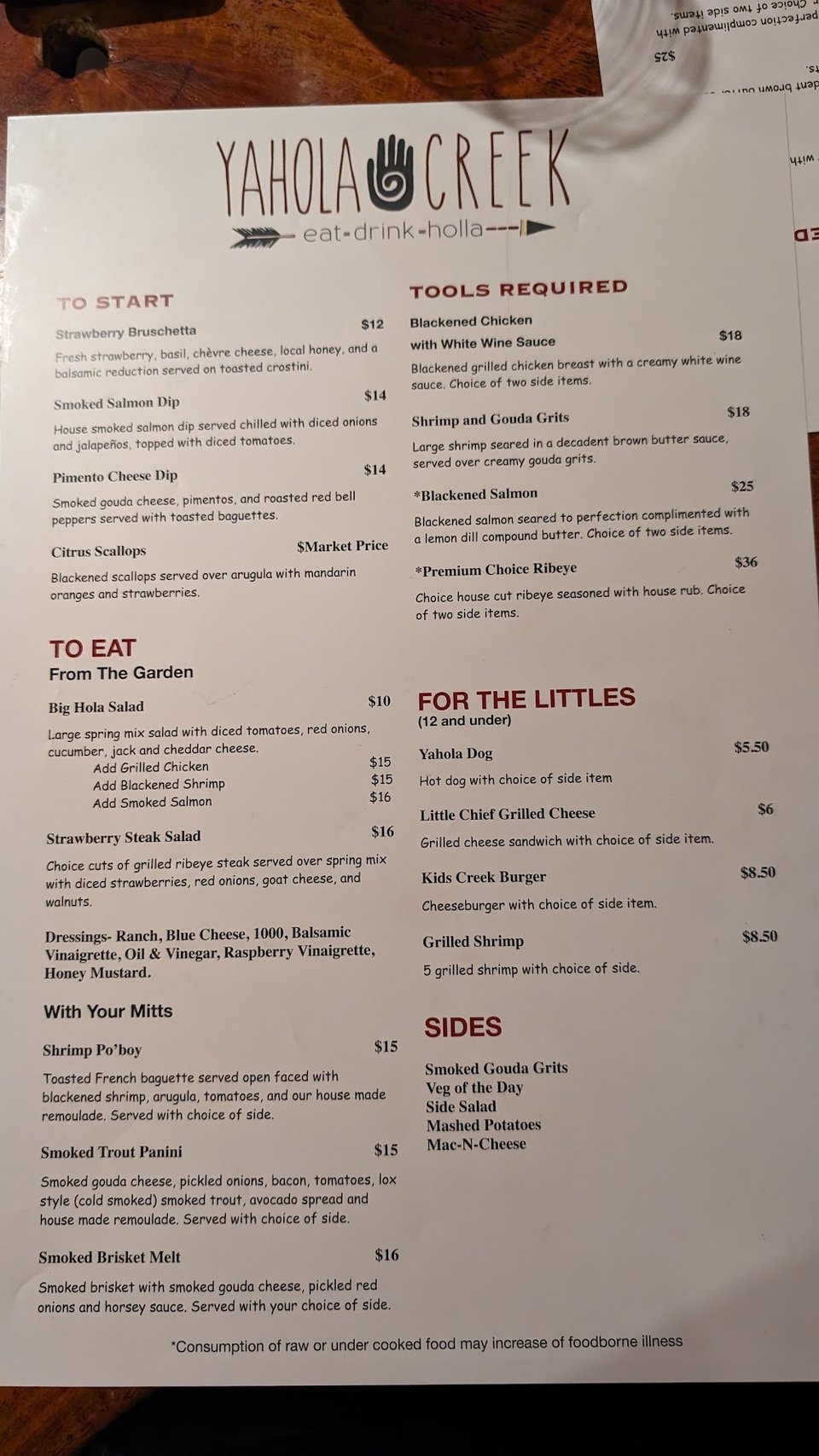 Printed menu beside a restaurant table.
